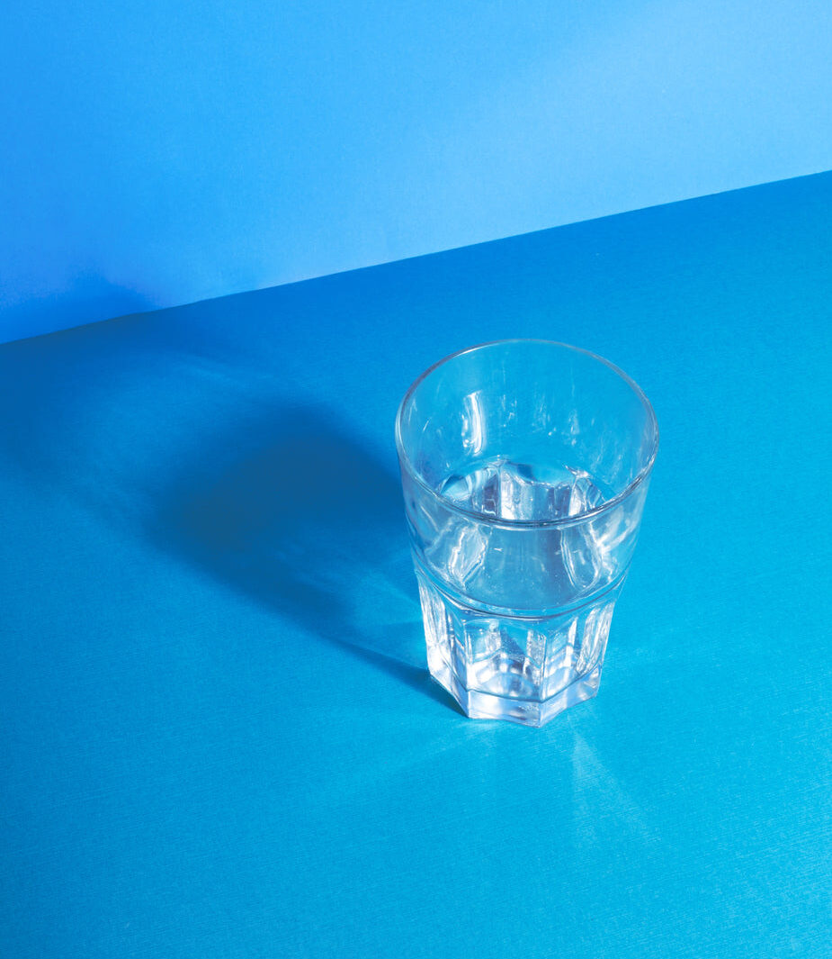 Drinking glass of water on blue background